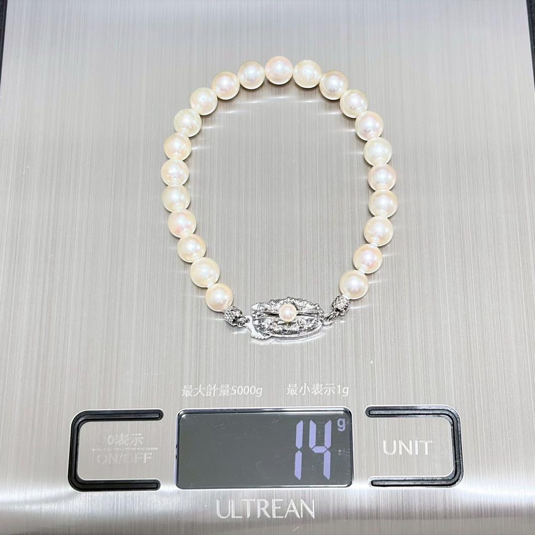 Akoya pearl double strand necklace and matching bracelet with silver clasp laid out on white background