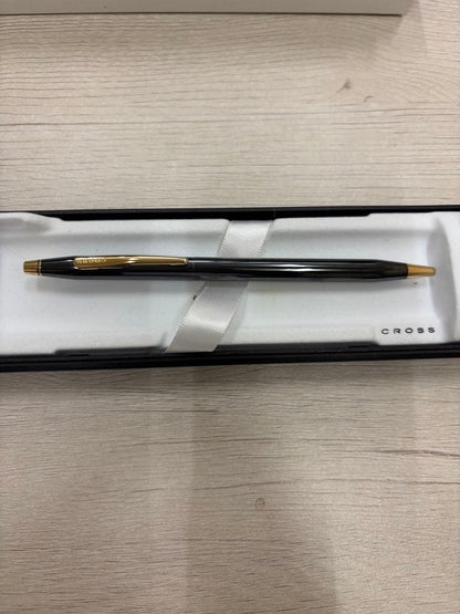Cross black ballpoint pen with gold accents displayed alongside its dedicated black case