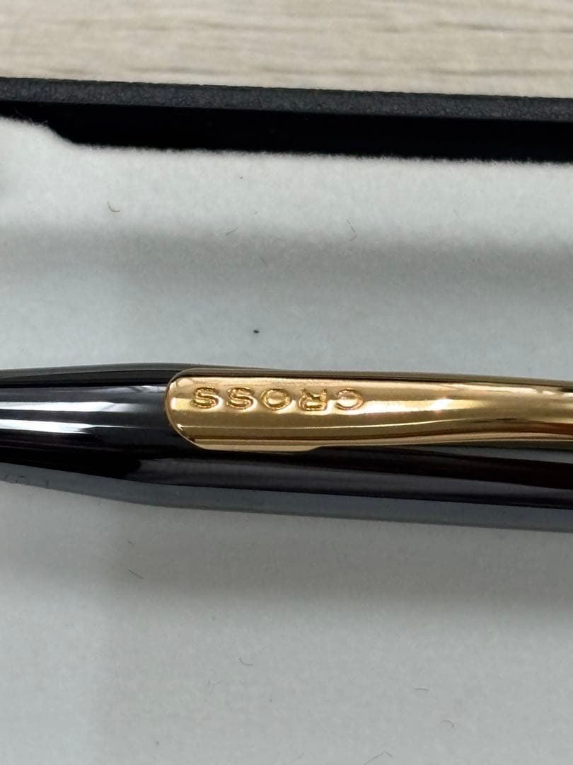 Cross black ballpoint pen with gold accents displayed alongside its dedicated black case