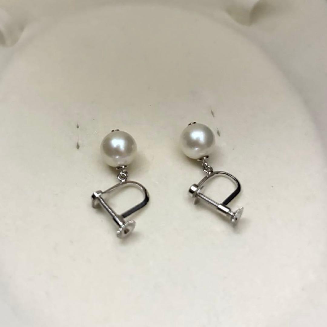 Large white Akoya pearl necklace and matching earrings with 8.5mm pearls and silver accents on white background