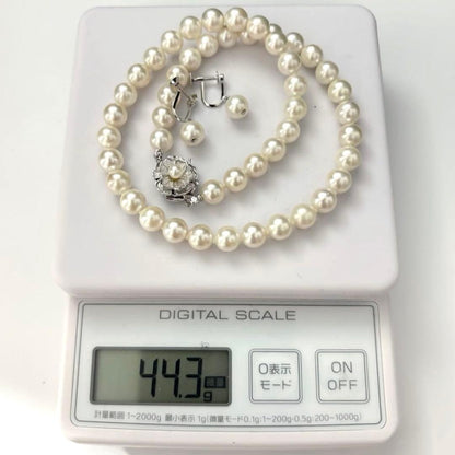 Large white Akoya pearl necklace and matching earrings with 8.5mm pearls and silver accents on white background