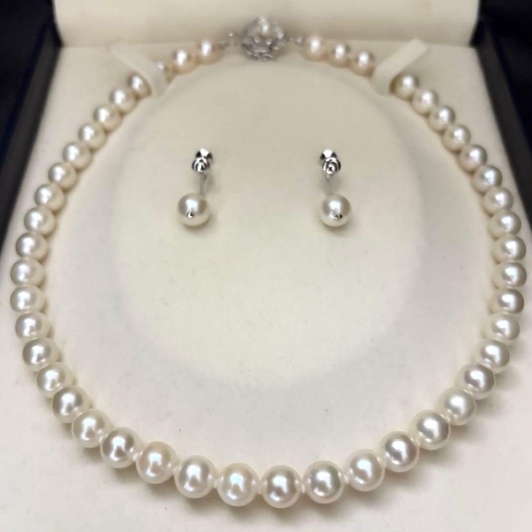 Large white Akoya pearl necklace and matching earrings with 8.5mm pearls and silver accents on white background