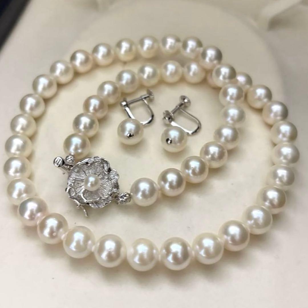 Large white Akoya pearl necklace and matching earrings with 8.5mm pearls and silver accents on white background