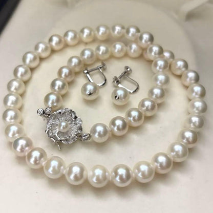 Large white Akoya pearl necklace and matching earrings with 8.5mm pearls and silver accents on white background