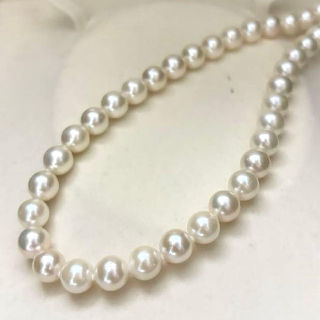 Large white Akoya pearl necklace and matching earrings with 8.5mm pearls and silver accents on white background