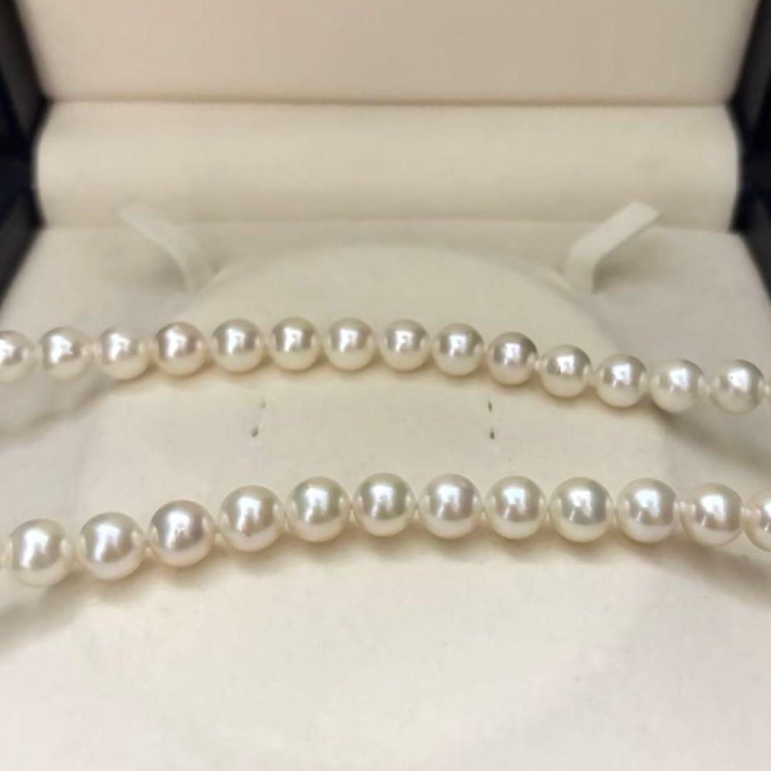 Large white Akoya pearl necklace and matching earrings with 8.5mm pearls and silver accents on white background