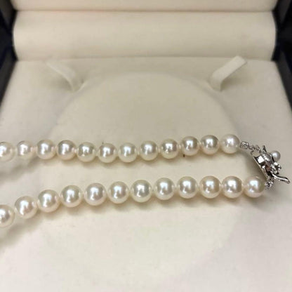 Large white Akoya pearl necklace and matching earrings with 8.5mm pearls and silver accents on white background