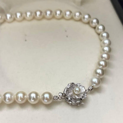 Large white Akoya pearl necklace and matching earrings with 8.5mm pearls and silver accents on white background