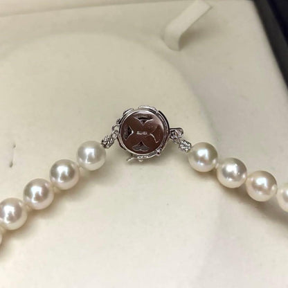 Large white Akoya pearl necklace and matching earrings with 8.5mm pearls and silver accents on white background
