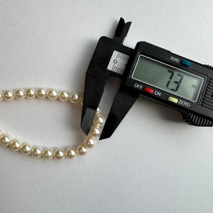 Akoya pearl necklace and earrings set featuring 7.3mm white and cream pearls displayed without accessory case