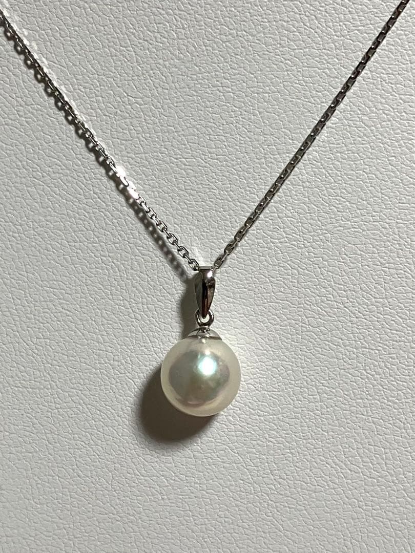 Akoya pearl pendant top with 8.6mm lustrous pearl and platinum 900 stamped Pt900 setting showing natural blemishes