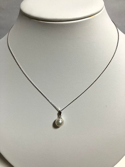 Akoya pearl pendant top with 8.6mm lustrous pearl and platinum 900 stamped Pt900 setting showing natural blemishes