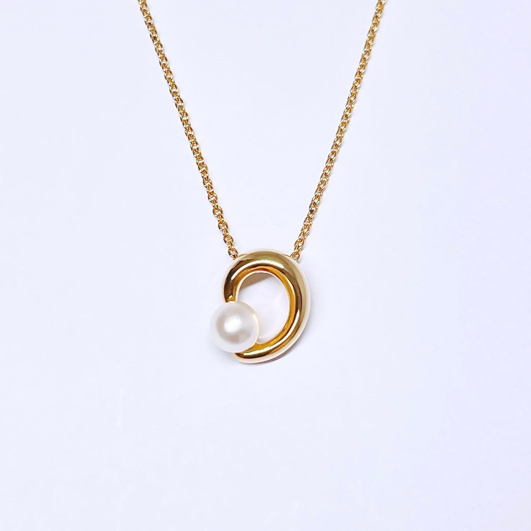 Tasaki pearl necklace pendant with 6.4 mm silver pearl and 45 cm gold chain on white background