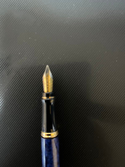 Waterman fountain pen with blue marble finish, gold trim, and medium gold nib on white background