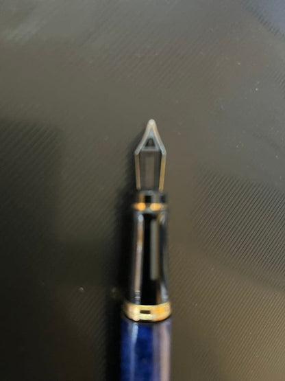 Waterman fountain pen with blue marble finish, gold trim, and medium gold nib on white background