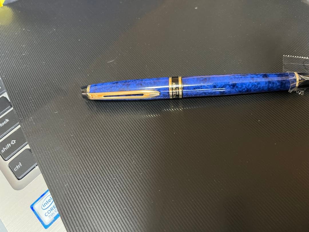 Waterman fountain pen with blue marble finish, gold trim, and medium gold nib on white background