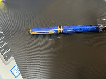 Waterman fountain pen with blue marble finish, gold trim, and medium gold nib on white background