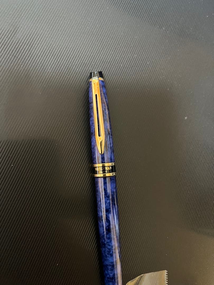 Waterman fountain pen with blue marble finish, gold trim, and medium gold nib on white background