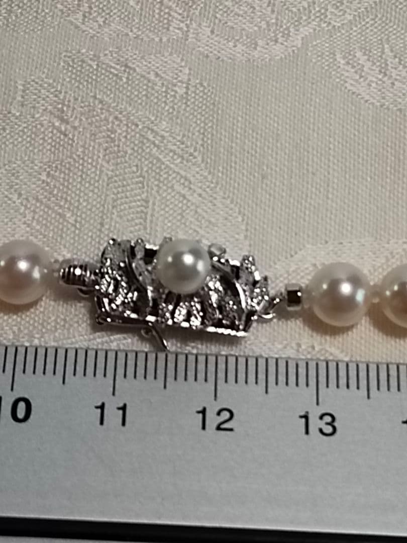 Akoya pearl necklace with 6.5-6.7mm cream-toned pearls and square silver clasp on a white background