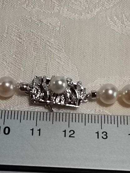 Akoya pearl necklace with 6.5-6.7mm cream-toned pearls and square silver clasp on a white background