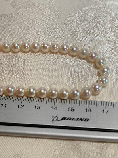 Akoya pearl necklace with 6.5-6.7mm cream-toned pearls and square silver clasp on a white background