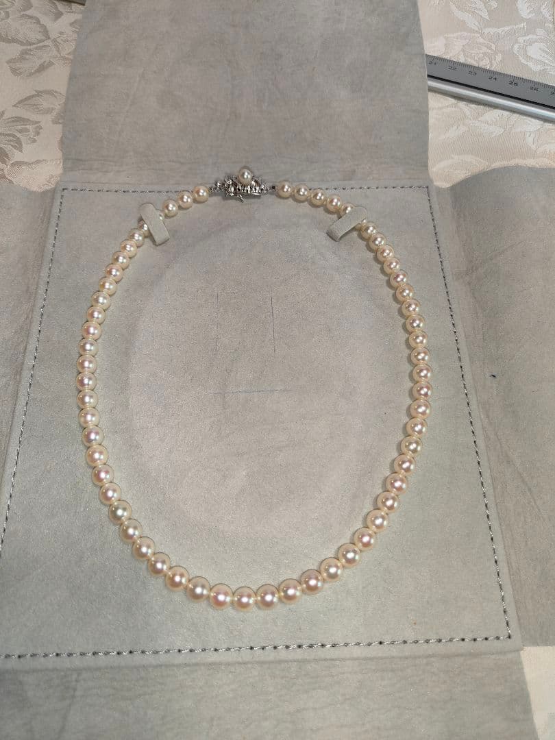 Akoya pearl necklace with 6.5-6.7mm cream-toned pearls and square silver clasp on a white background