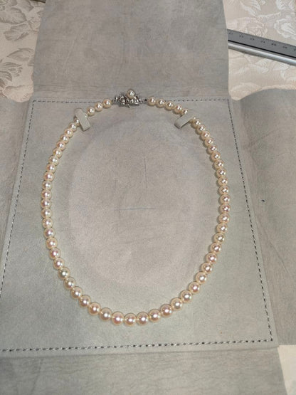 Akoya pearl necklace with 6.5-6.7mm cream-toned pearls and square silver clasp on a white background
