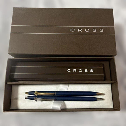 Cross 2-piece ballpoint pen set in gold and silver with navy accents, displayed with gift box and manual