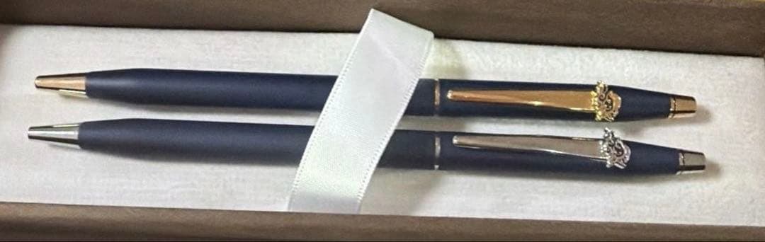 Cross 2-piece ballpoint pen set in gold and silver with navy accents, displayed with gift box and manual