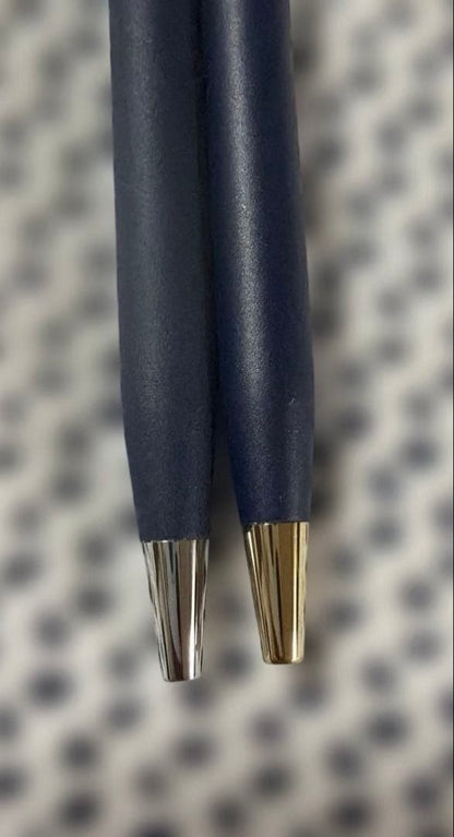 Cross 2-piece ballpoint pen set in gold and silver with navy accents, displayed with gift box and manual