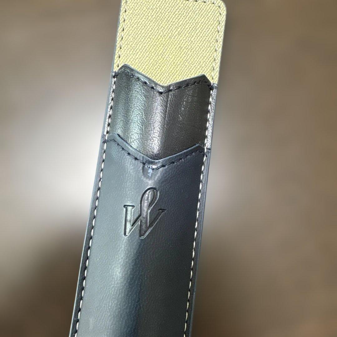 Used Waterman black ballpoint pen with a leather case showing a dent