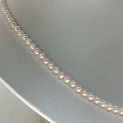 Close-up of Akoya pearl necklace featuring 4-4.5mm lustrous white pearls on a delicate strand