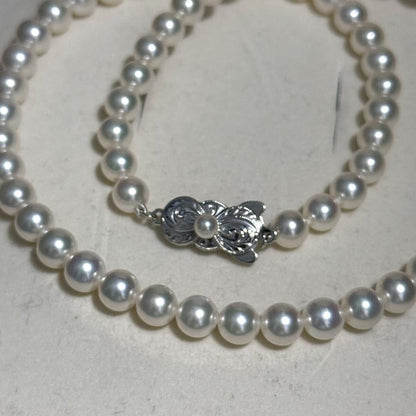 Mikimoto Akoya pearl necklace with 6.5mm pearls and silver clasp on a white background