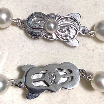 Mikimoto Akoya pearl necklace with 6.5mm pearls and silver clasp on a white background