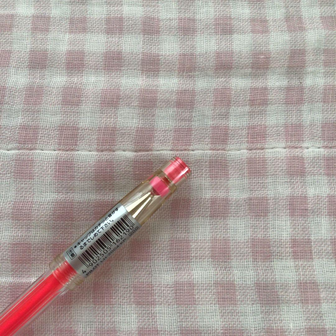 Pilot Hi-Tec C ballpoint pen in fluorescent pink with ink visible, discontinued edition