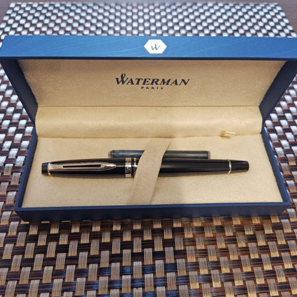 Waterman black fountain pen with blue ink cartridge and dedicated black case on white background