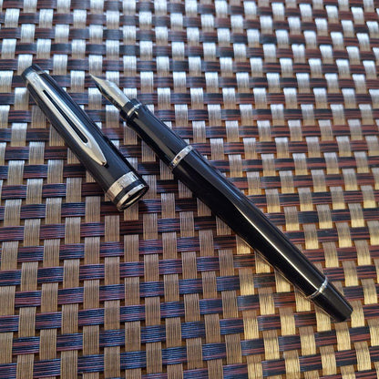 Waterman black fountain pen with blue ink cartridge and dedicated black case on white background