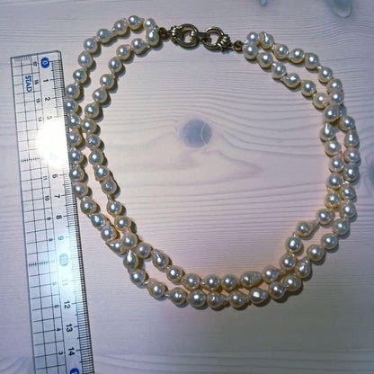 Two-row Akoya pearl necklace about 40cm long with clasp on white background