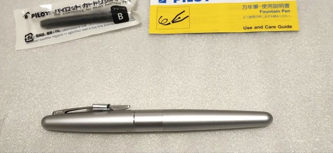 Pilot Kakuna Silver fountain pen with medium nib shown unused with packaging and black ink cartridge