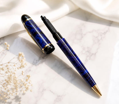 WATERMAN ballpoint pen with deep blue marble body and gold trim shown uncapped with blue ink tip