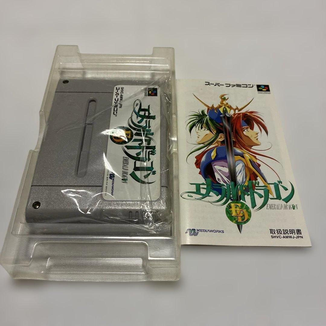 Emeraudo Doragon SNES game with original box, manual, postcard, and pamphlet displayed