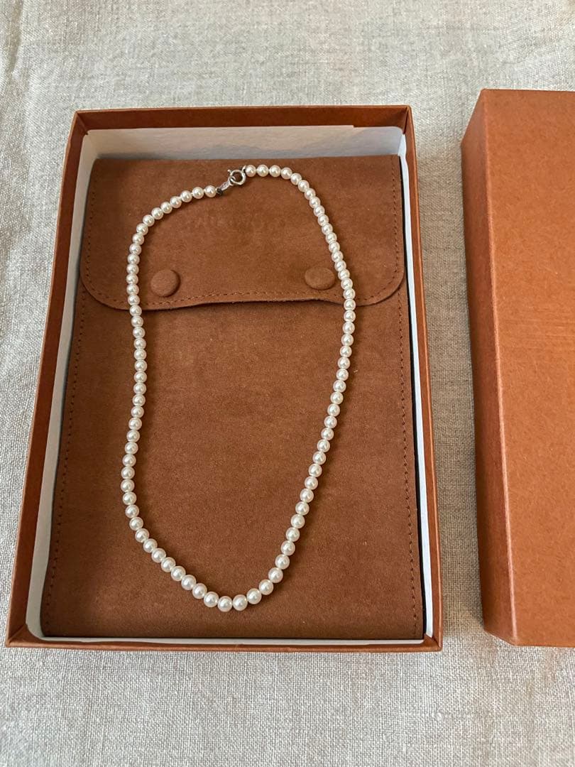 Close-up of Mikimoto pearl necklace with 3.5mm pearls and 36cm length on a white background