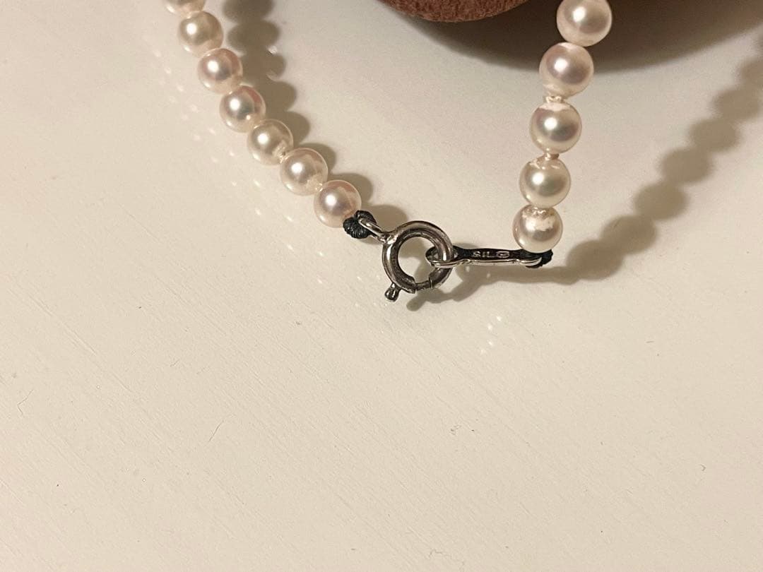 Close-up of Mikimoto pearl necklace with 3.5mm pearls and 36cm length on a white background