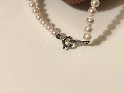 Close-up of Mikimoto pearl necklace with 3.5mm pearls and 36cm length on a white background