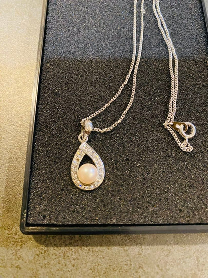 Akoya pearl necklace with 6mm pearls, zirconia accents, and a 38cm chain on a white background