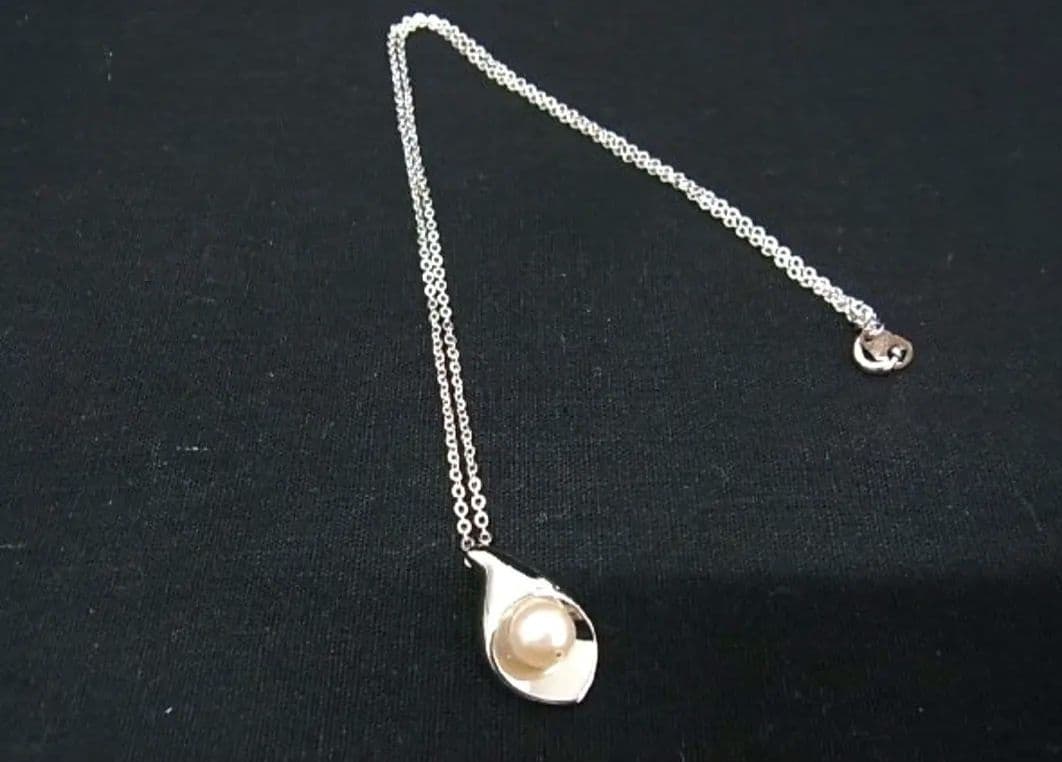 Tasaki pearl necklace with 6mm pearls and 16-inch length displayed on a white background