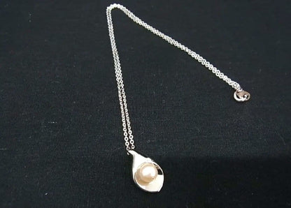 Tasaki pearl necklace with 6mm pearls and 16-inch length displayed on a white background