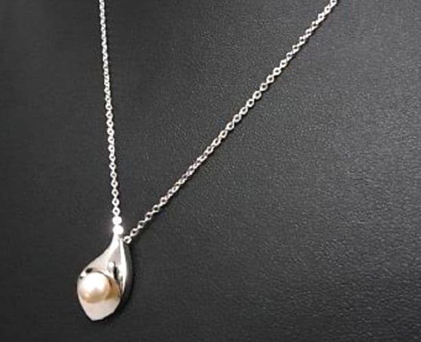 Tasaki pearl necklace with 6mm pearls and 16-inch length displayed on a white background