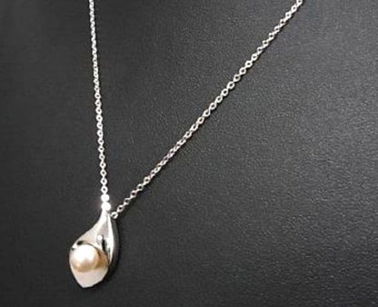 Tasaki pearl necklace with 6mm pearls and 16-inch length displayed on a white background