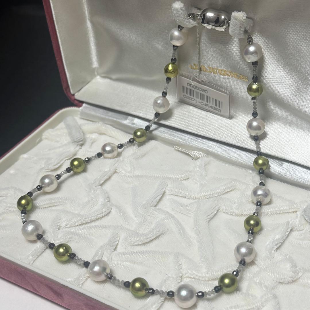 Akoya pearl necklace with pistachio dye pearls and silver findings on a white background